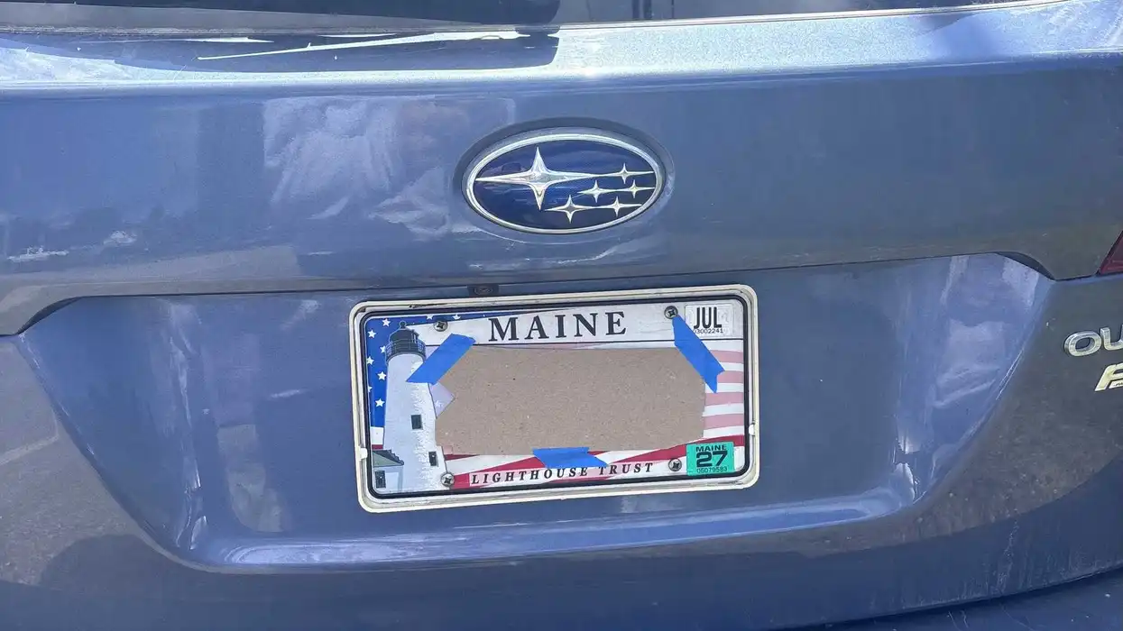A masked protester's illegally covered license plate at a Sept. 18 protest in Scarborough, Maine.