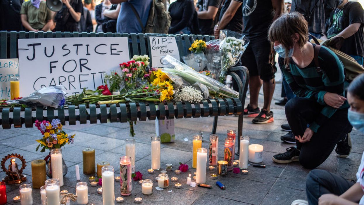 Candles, flowers, and signs for Garrett Foster