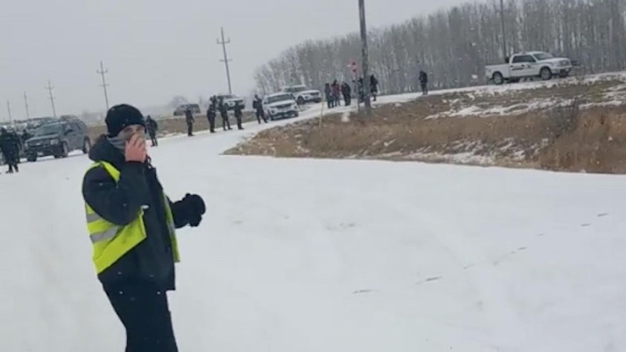 Dozens of police barricade Canadian church parking lot to keep worshippers out of drive-in service. So they line the highway instead.