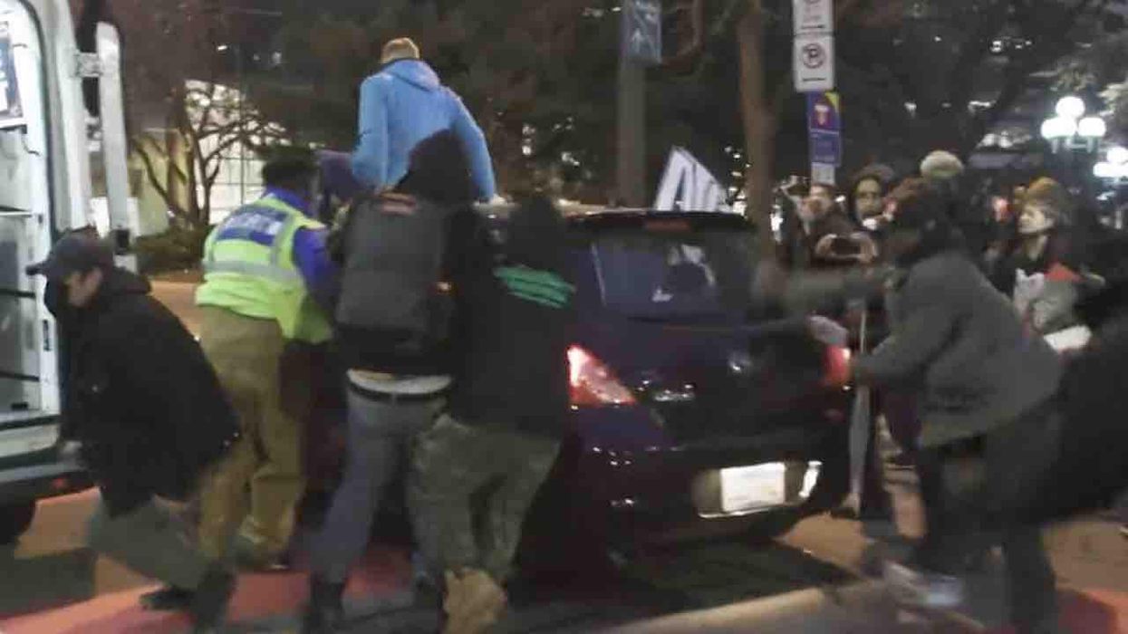 Enraged leftists climb atop, pound on, and chase car as driver navigates through Daunte Wright street protest that Minneapolis apparently didn't sanction