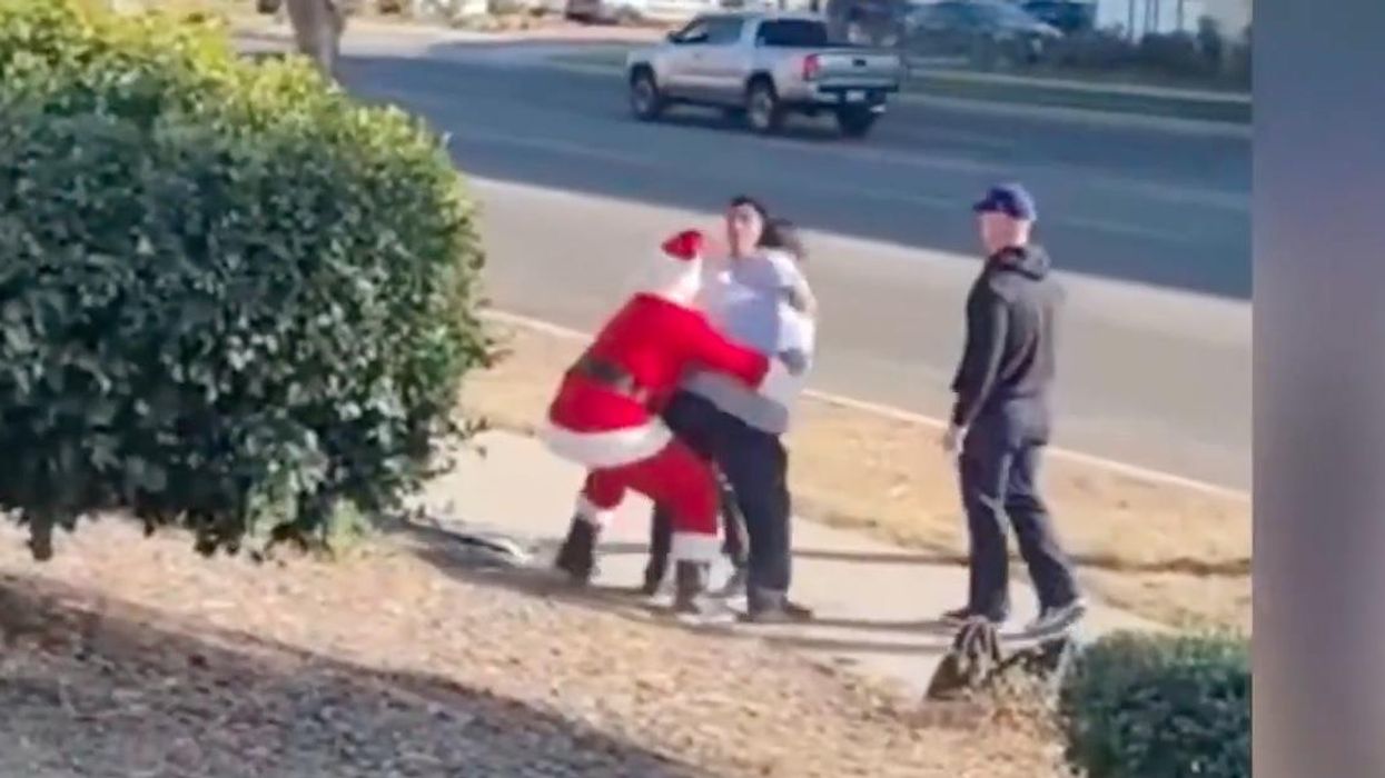 'Get him, Santa!': Cop dressed as Santa tackles suspected car thief as 'elf' partner detains alleged accomplice at gunpoint