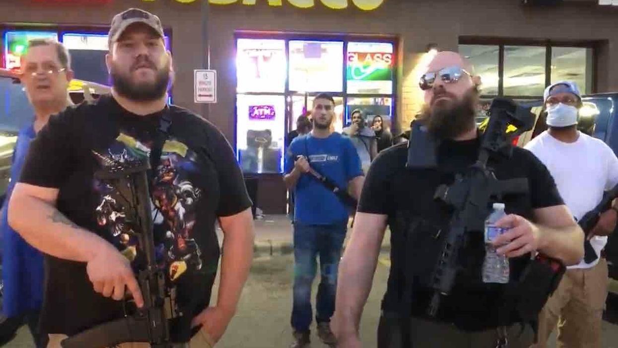 Heavily armed rednecks' who support protesters stand in front of tobacco store to prevent looting