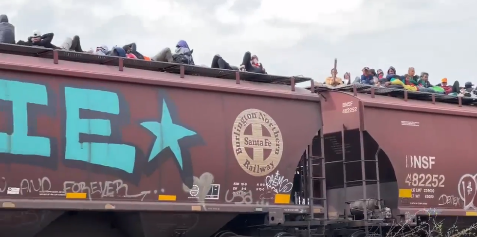 Hundreds of migrants ride on top of train in Mexico headed for US border