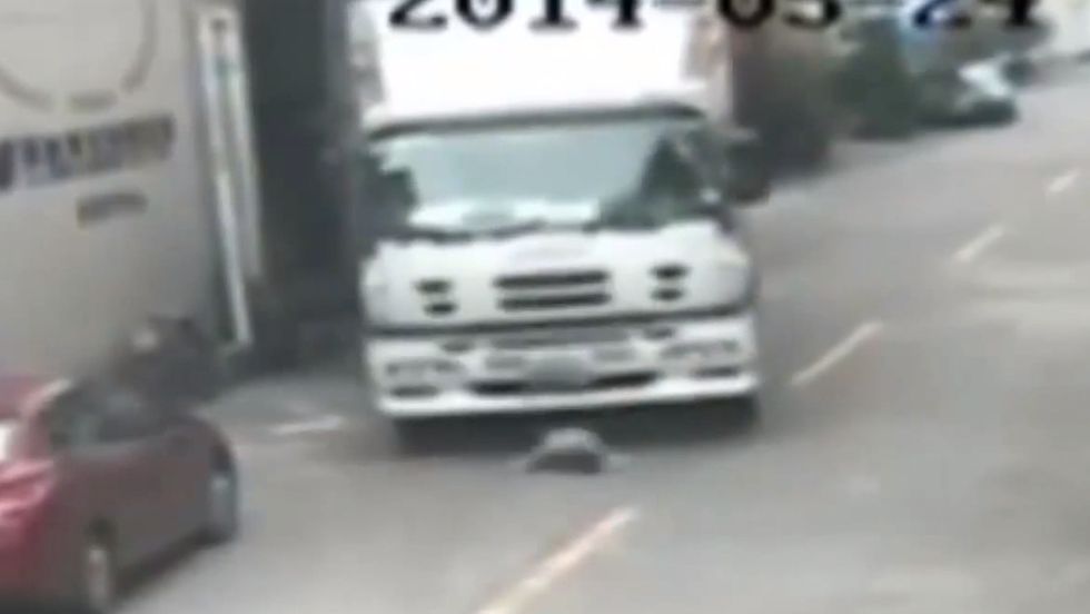Stunning Video: Elderly Woman Survives Being Run Over by a Truck