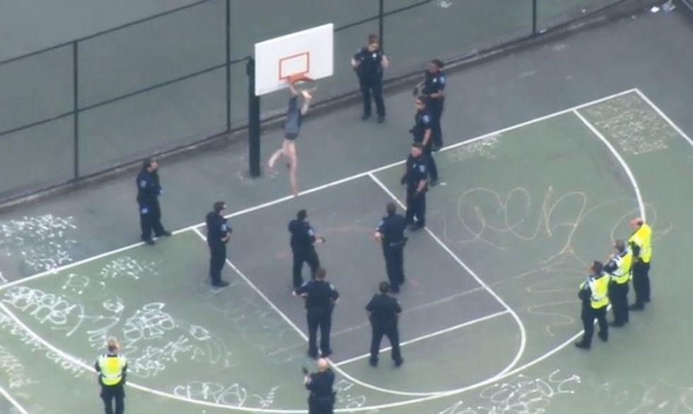 Shirtless, Hanging Upside Down, Swinging a Hammer at Police -- Possibly the Strangest Arrest Made During Last Friday's 'May Day' Marches