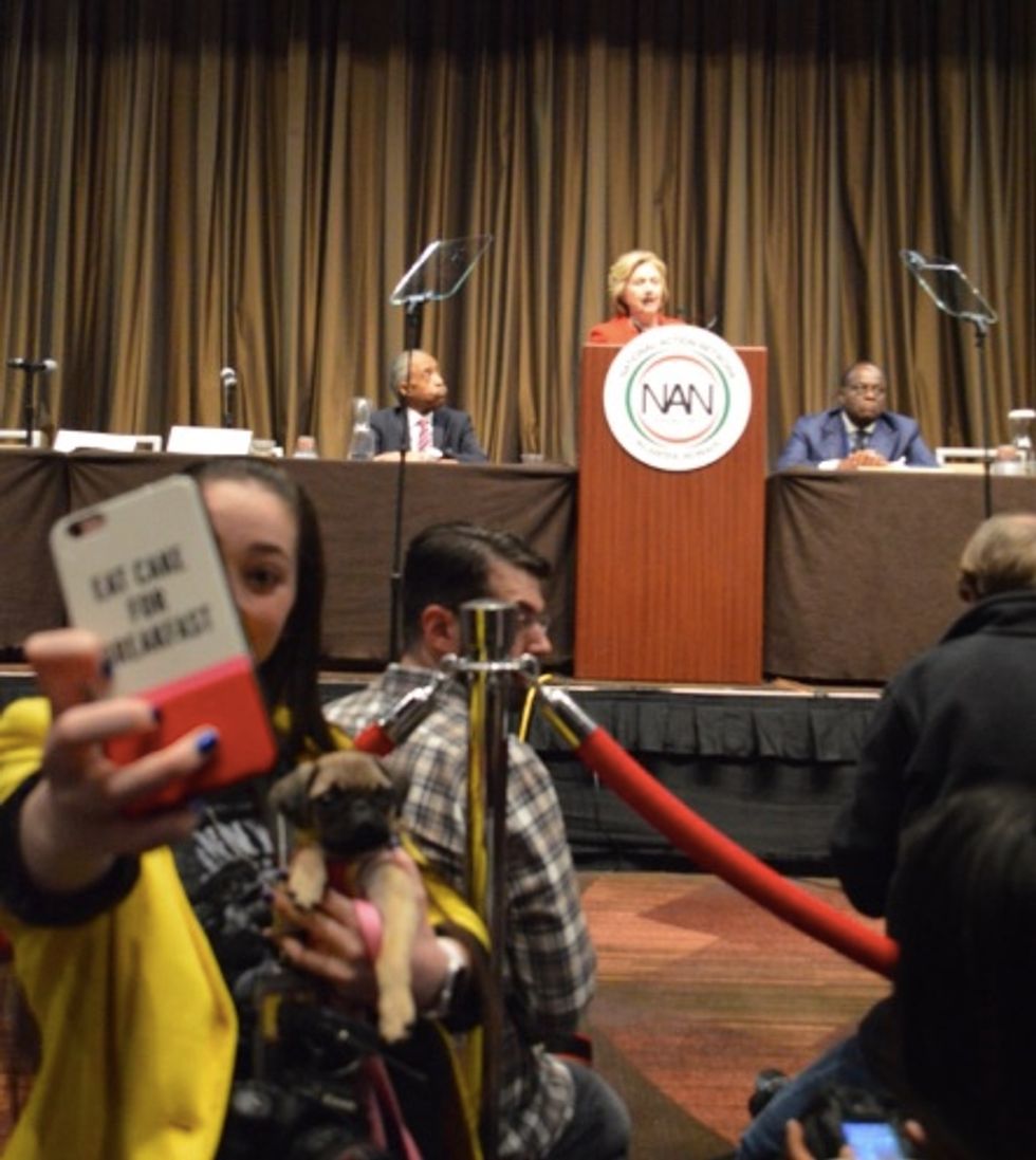 Reporter at Clinton Speech Caught Snapping Selfies While Holding a Dog