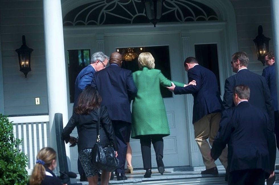 Rumor Check: Photo of Clinton Being Helped Up Stairs Goes Viral — but There’s More to the Story