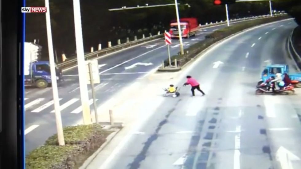 See stunning footage of toddler who walks away after being run over by massive truck