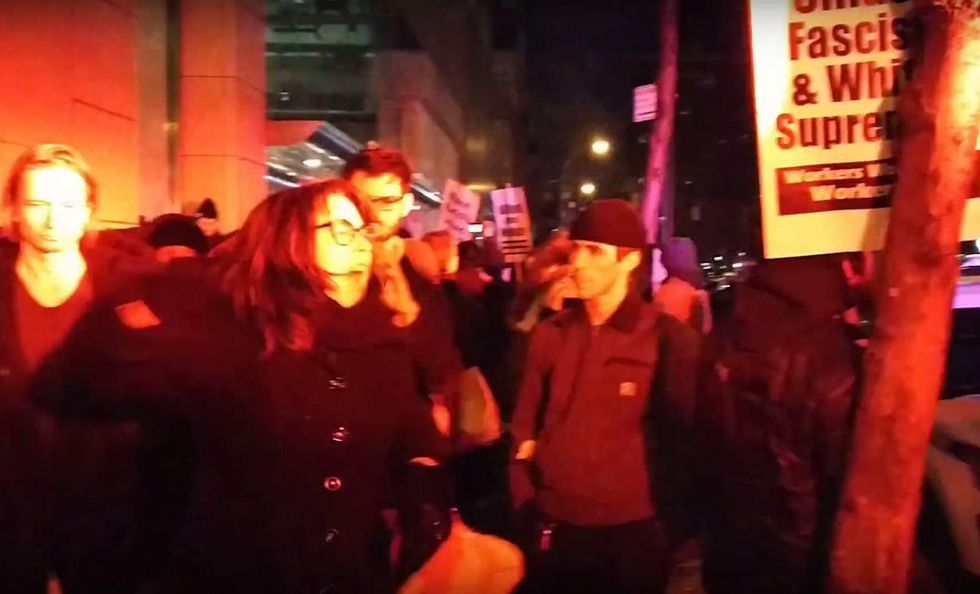 Watch liberal 'professor' absolutely lose it in explosive rant at cops during 'neo-Nazi' protest