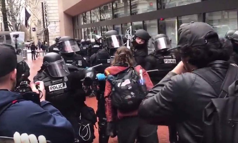 Female protester gives cops the finger, reportedly tries to spit at them. So they lay down the law.