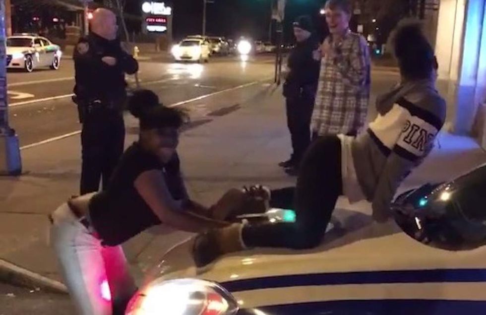 Outrageous video: Females twerk on hood of police cruiser as cop crosses his arms and watches