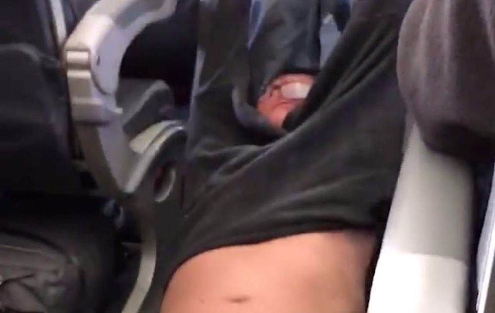 Watch screaming passenger get dragged off plane after airline overbooked flight