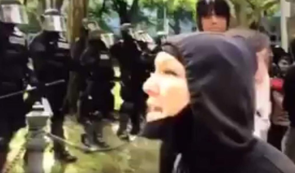 Self-proclaimed preschool teacher in leftist antifa garb rips riot police with profanity-laced rant