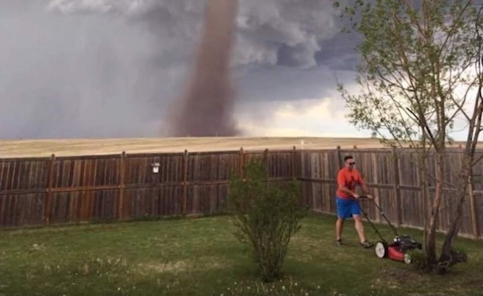 As tornado twists nearby, one guy has a more pressing task at hand than simply taking cover