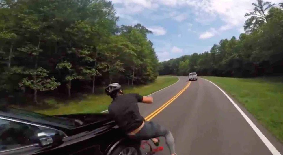 Watch: School faculty member allegedly sideswipes a bicyclist — and keeps going