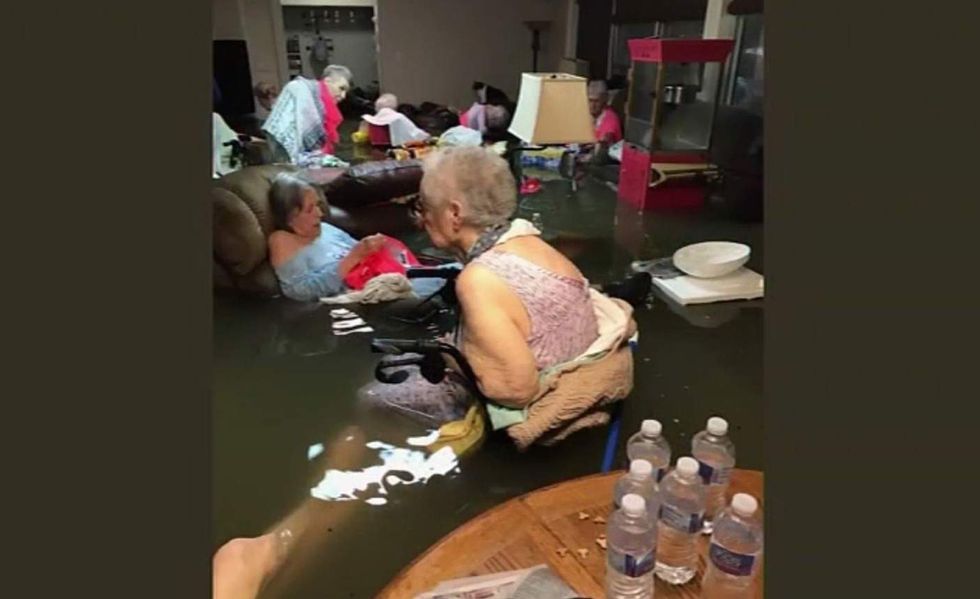 The story behind this viral photo of elderly women in waist deep flood water is insane