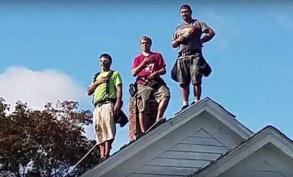 Roofers atop house hear the national anthem at HS football game. Their reaction is going viral