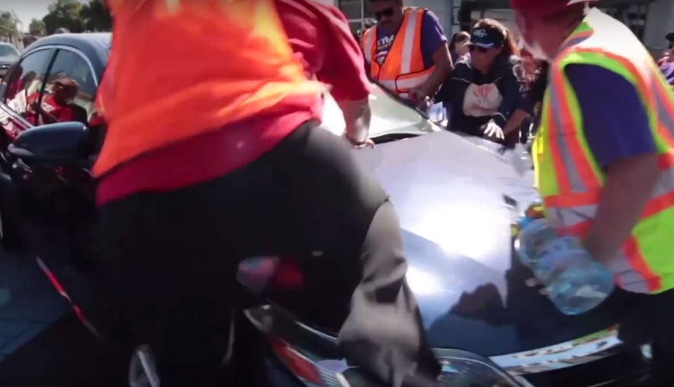 Motorist arrested after video shows vehicle drive at low speed through crowd of angry protesters