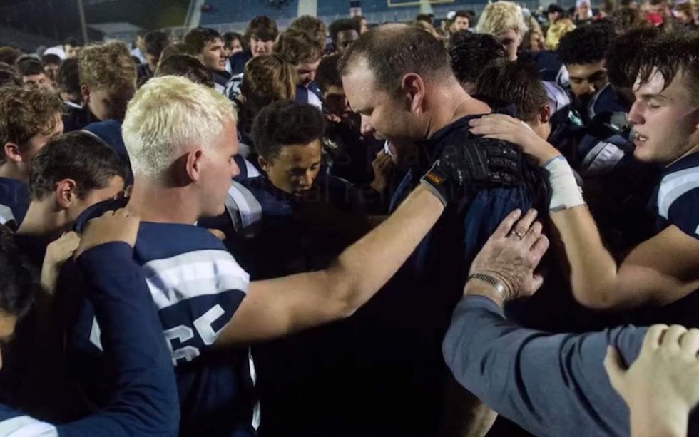 Atheists target HS football coach seeming to pray with players—but district apparently isn't caving