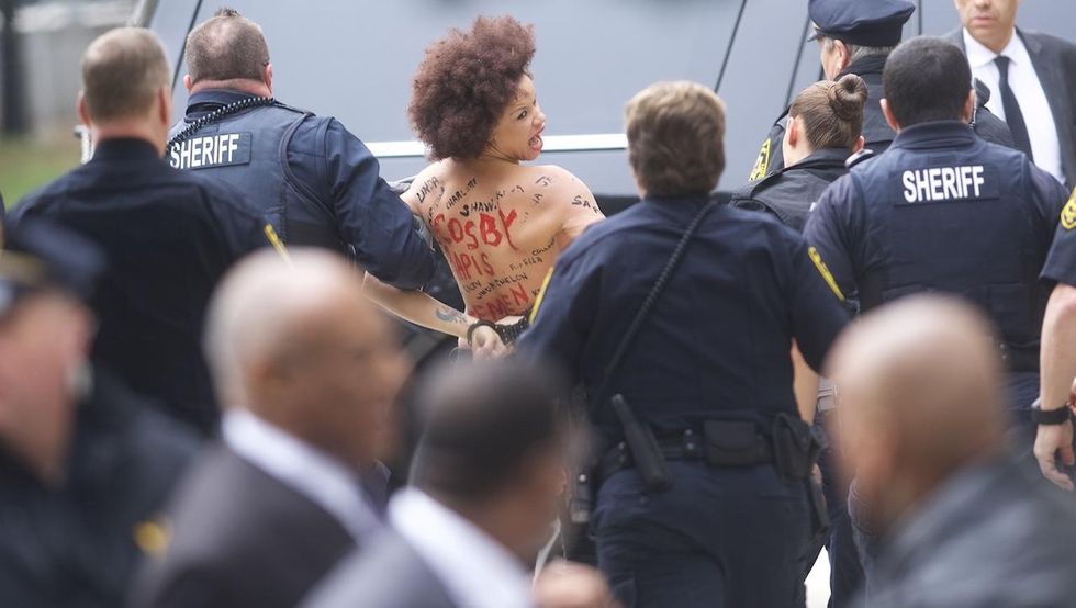 Topless protester chanting 'Women's lives matter' lunges at Bill Cosby outside Pa. courthouse