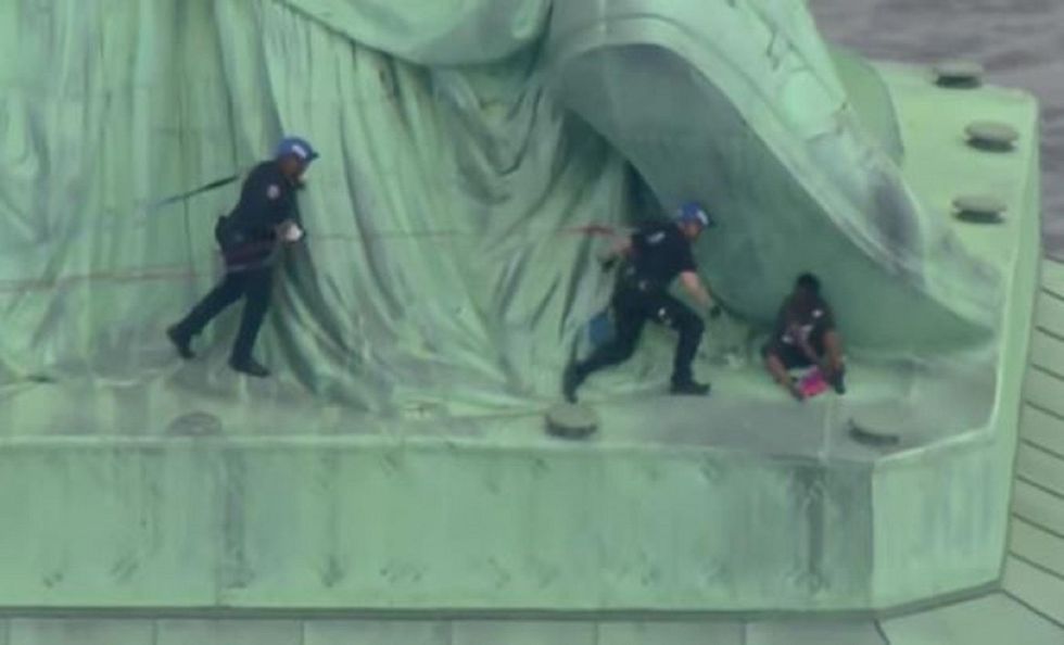 Statue of Liberty evacuated as woman scales base - several protesters ...