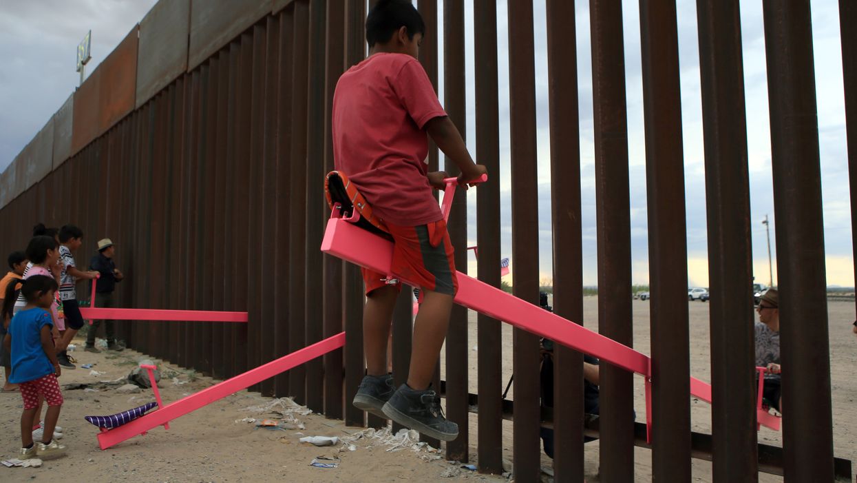 Two professors have created seesaws so that children can play across the border fence