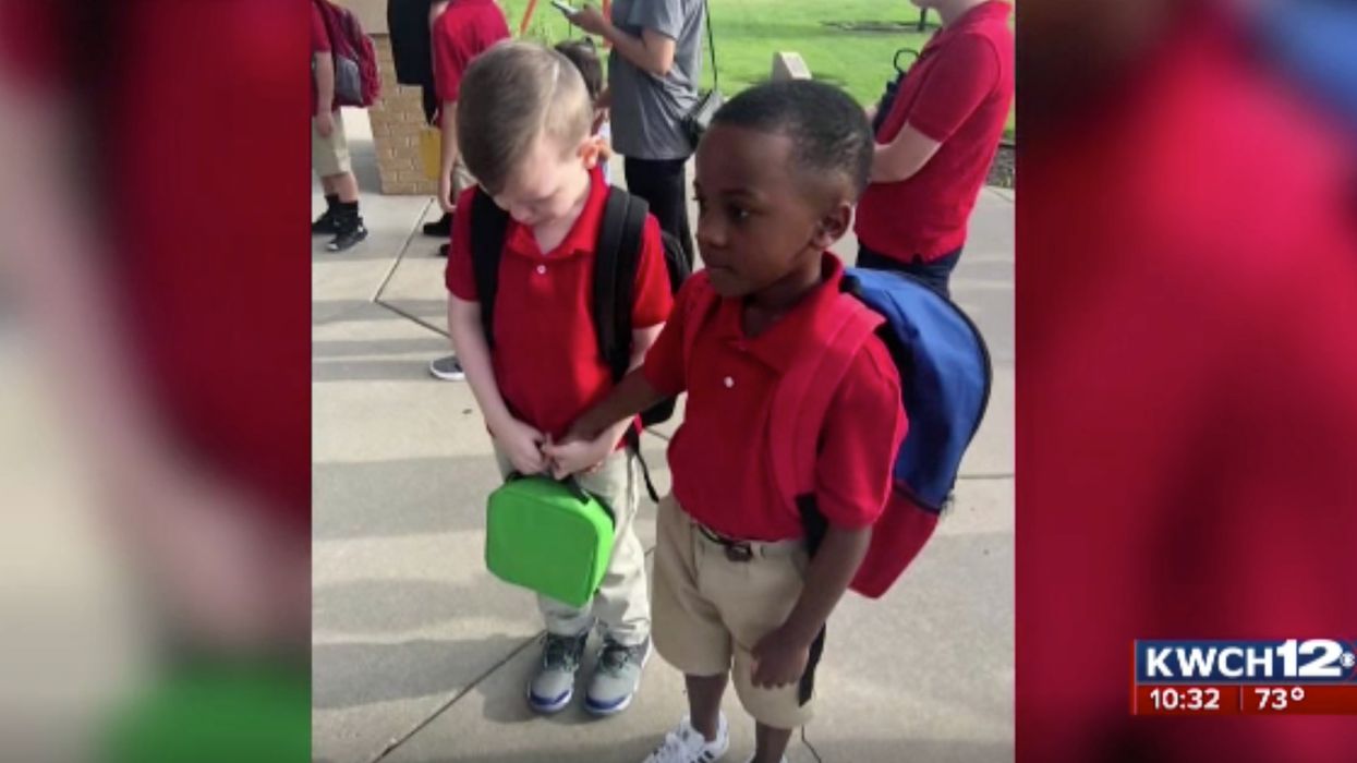 First grader consoles his frightened autistic classmate on the first day of school. The moving photo goes viral.