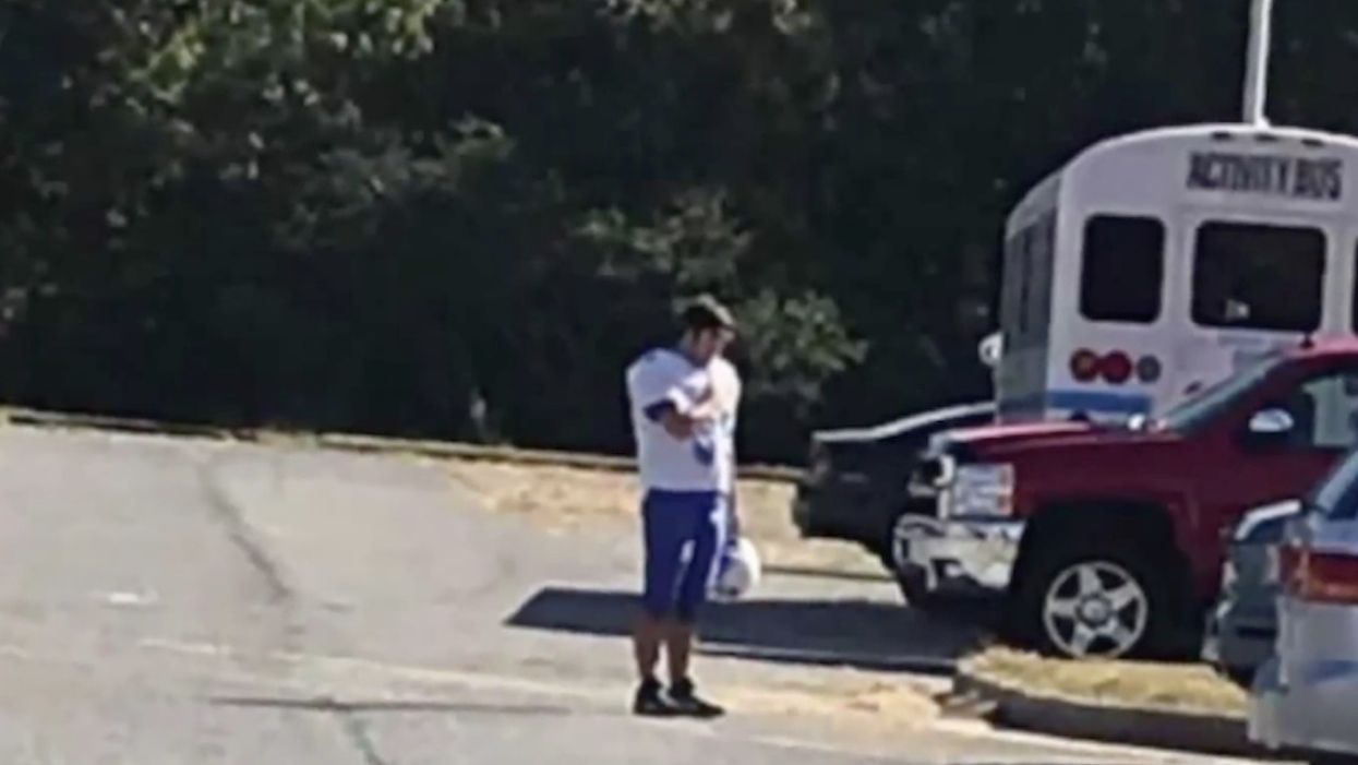 Photo of HS football player stopping for national anthem — by himself in a parking lot — is touching hearts