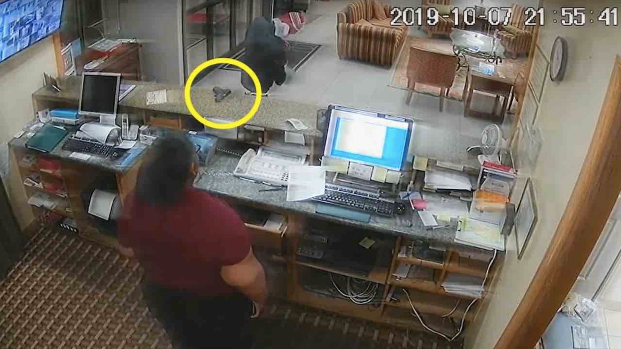 Crook puts gun on counter while turning his head and stuffing cash in bag — then brave hotel clerk seizes the moment