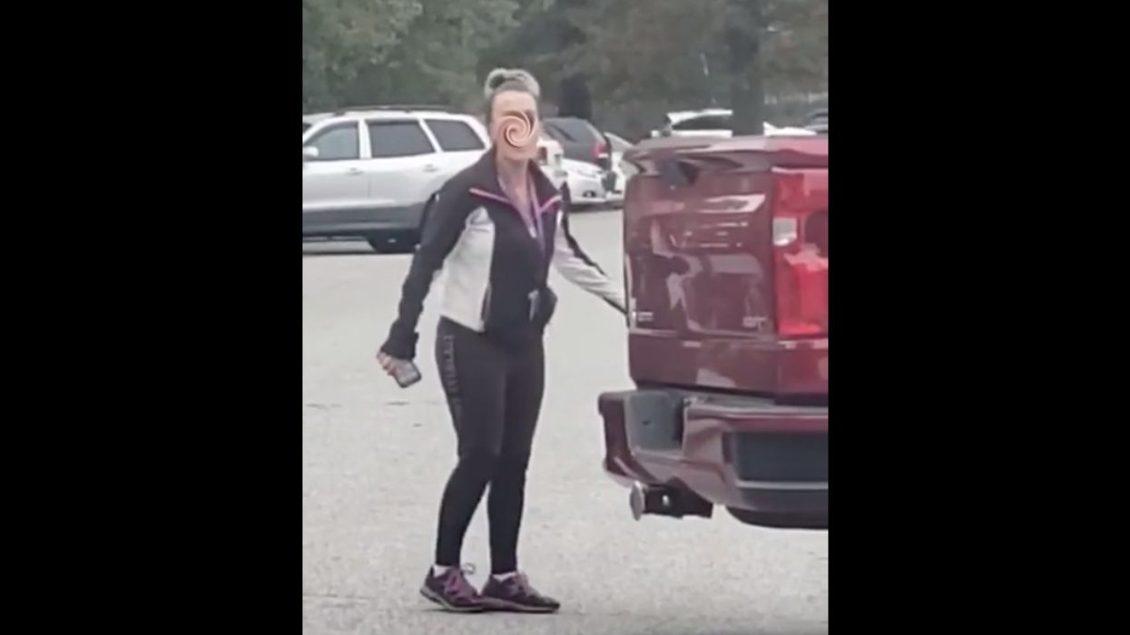 Teacher is suspended after she loses it on a parent during racist rant in school parking lot. The ugly interaction is caught on video.