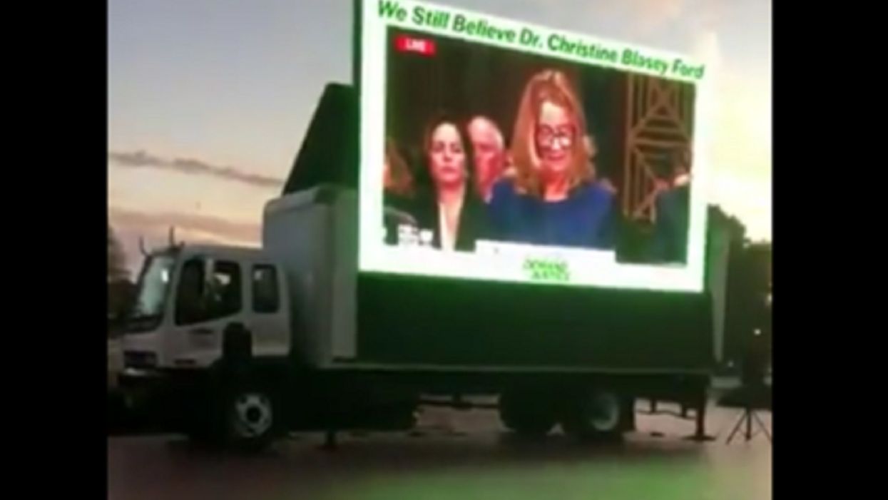Activists play Blasey Ford testimony on big screen outside Justice Kavanaugh speech