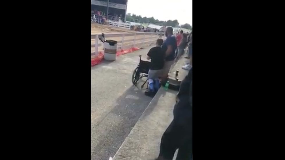 Boy in wheelchair hears national anthem, pulls himself to his feet for America