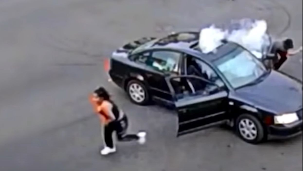 Video catches the moment a protester's large firework is tossed back into his car and explodes