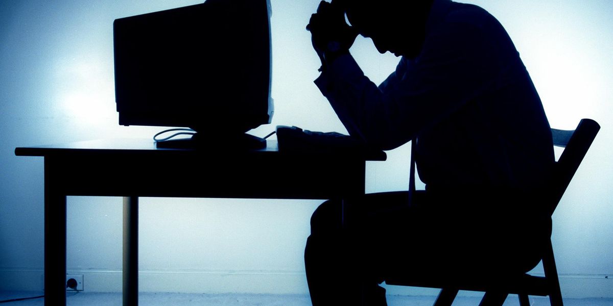 геймер в отчаянии держится за голову перед монитором