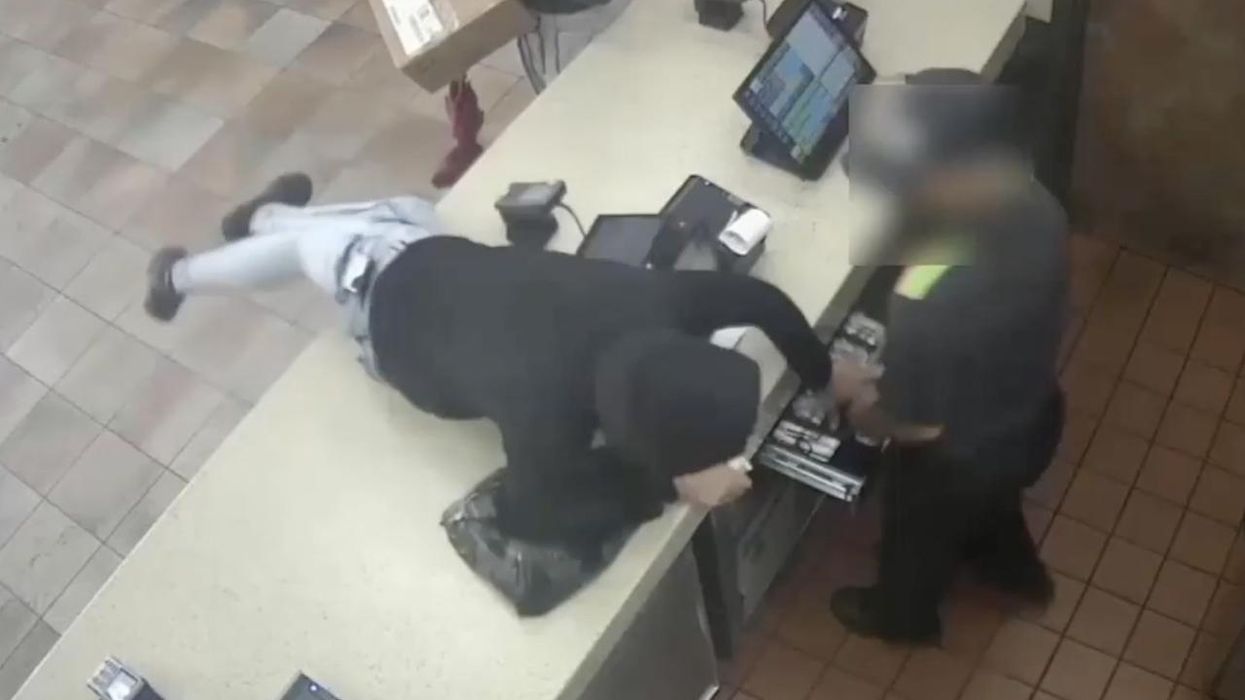 Woman in hoodie leaps across Burger King counter in Bronx, tries to steal register cash. Workers drag her toward kitchen, but soon, she just casually walks out.