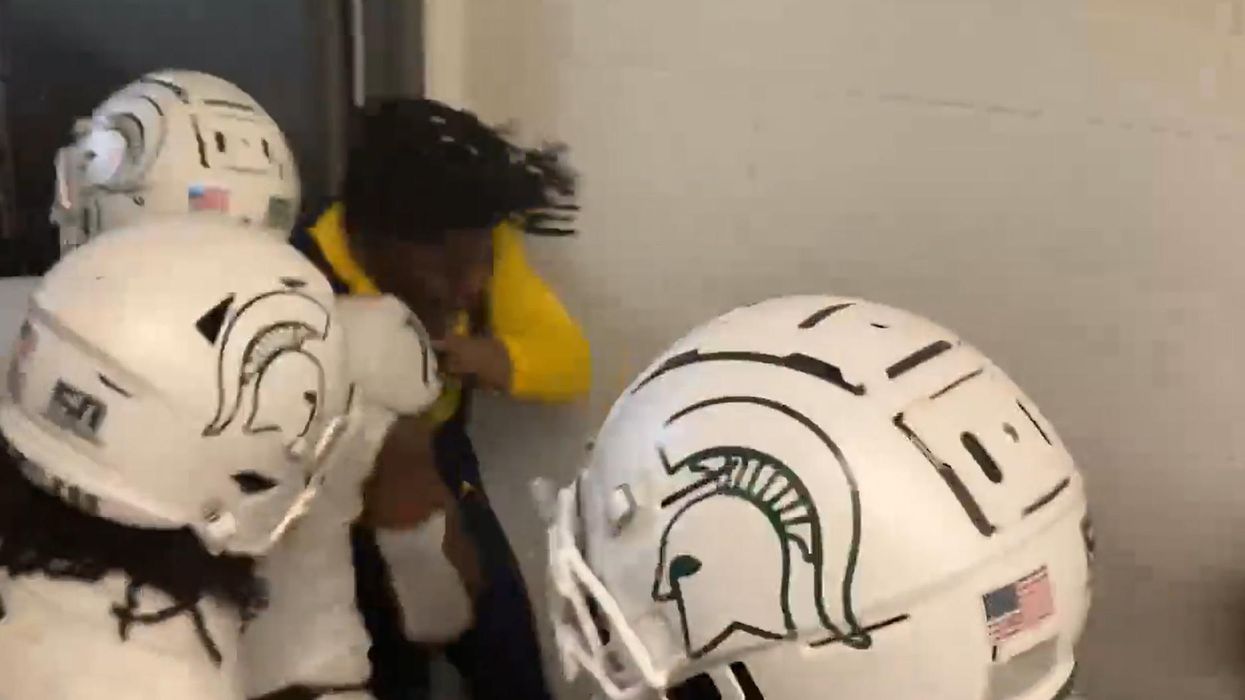 Video: Numerous Michigan State football players gang up on lone Michigan player, punching, kicking, and throwing him to ground in stadium tunnel after MSU loss
