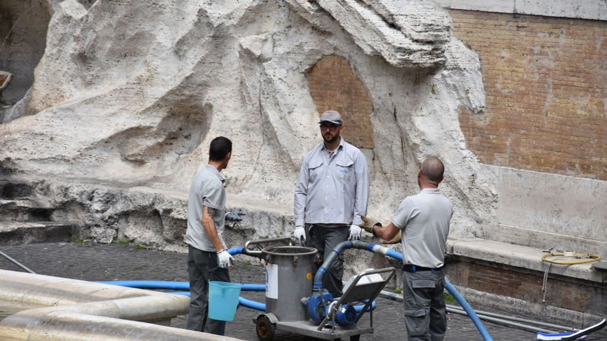 Climate vandals blacken water in Rome's Trevi Fountain; police drag them away