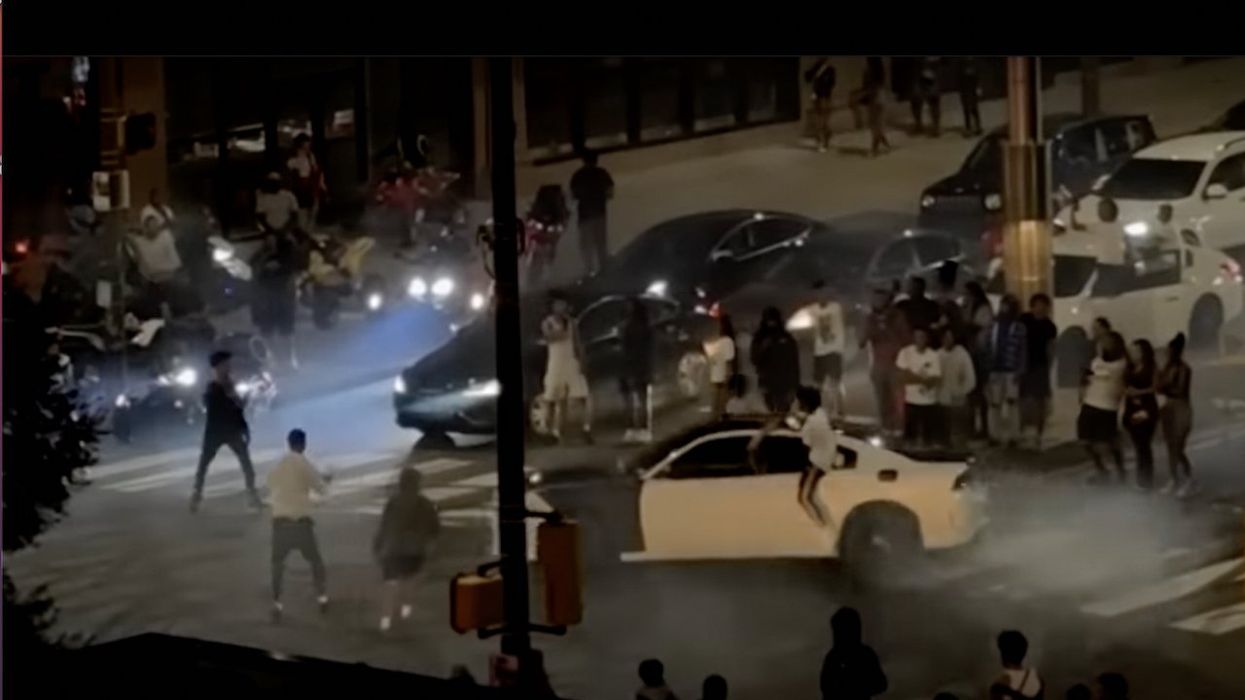 Mob of 500 takes over intersection, gawks at cars doing donuts at 2 a.m. After cops move in, officer is hit by vehicle — and driver flees scene.