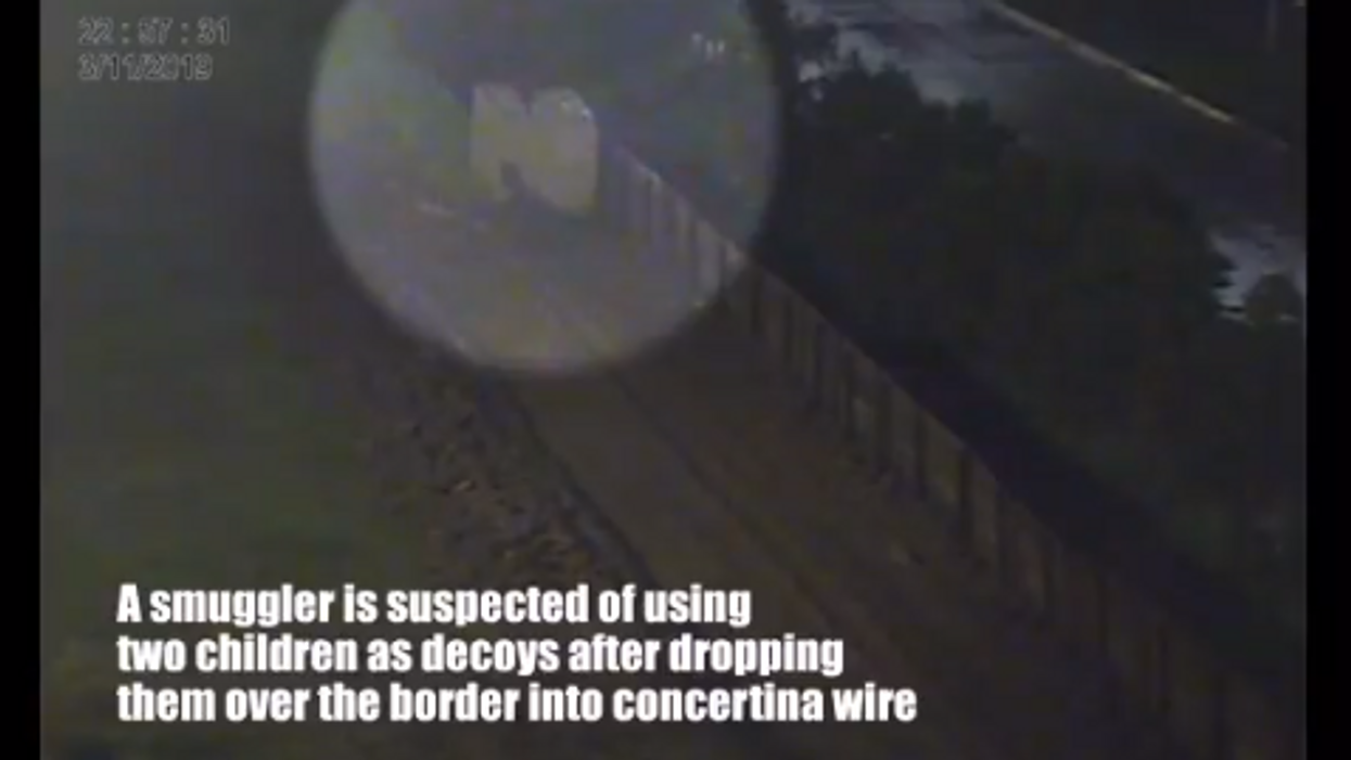 Smuggler diverts border agents by dropping two young girls from atop border barrier