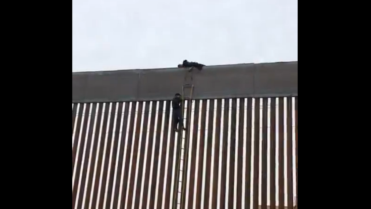 Viral video shows people climbing up the new US-Mexico border wall and sliding down the other side