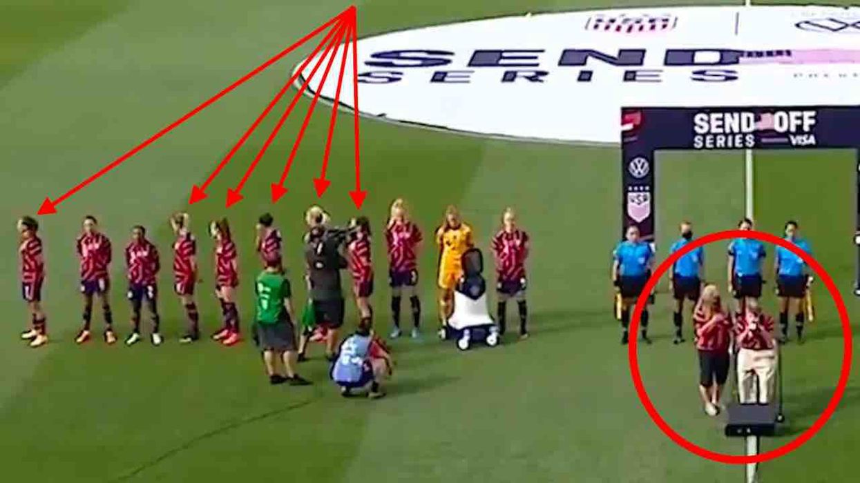 It's claimed some US women soccer players turned backs on 98-year-old WWII vet playing national anthem. But team says they were facing US flag.