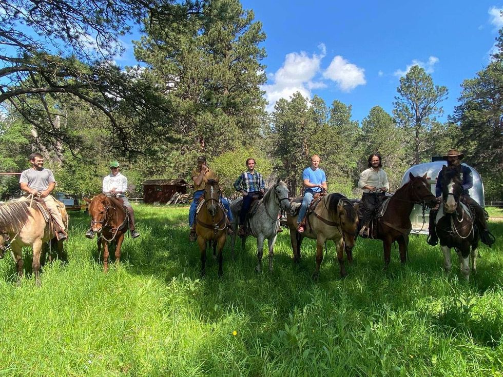 Men on horseback smile for a picture at the Wagon Box resort in Story, Wyoming.