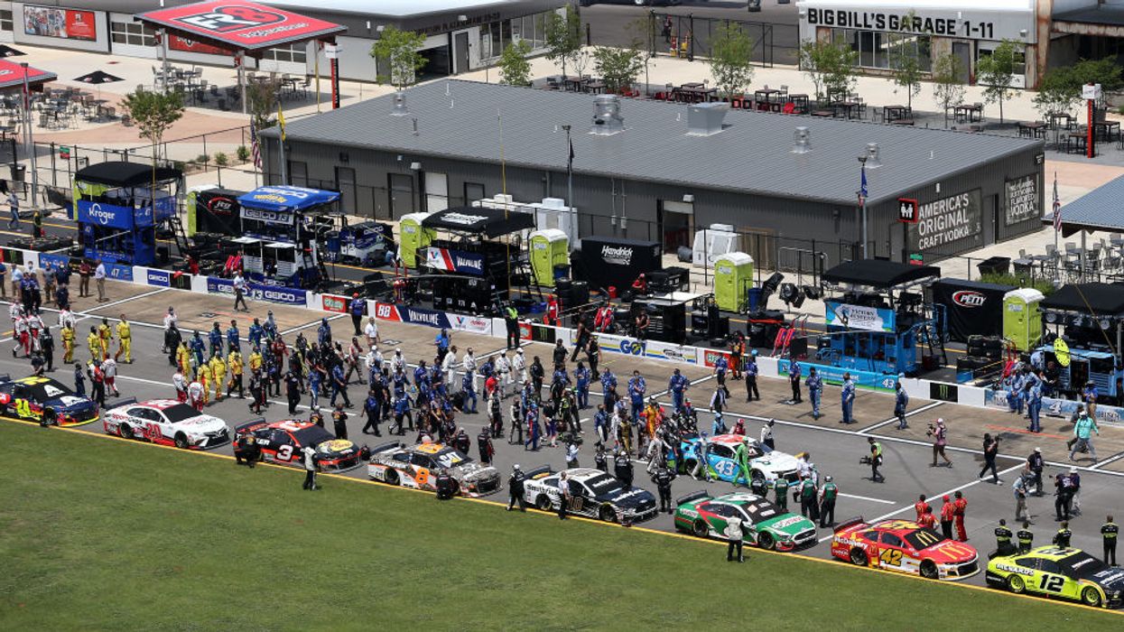 Multiple NASCAR drivers and crew members join in pushing Bubba Wallace's car to the front of the pack at Talladega