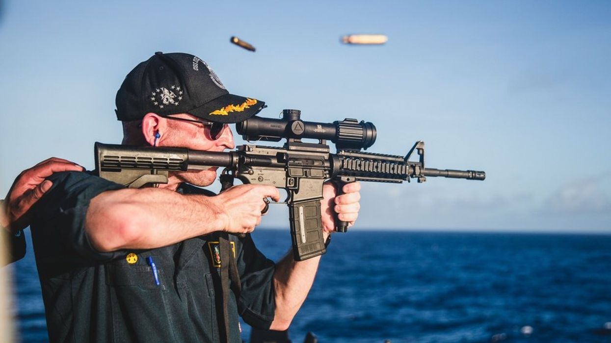 Navy torpedoes embarrassing post showing commanding officer firing rifle with backward and covered scope