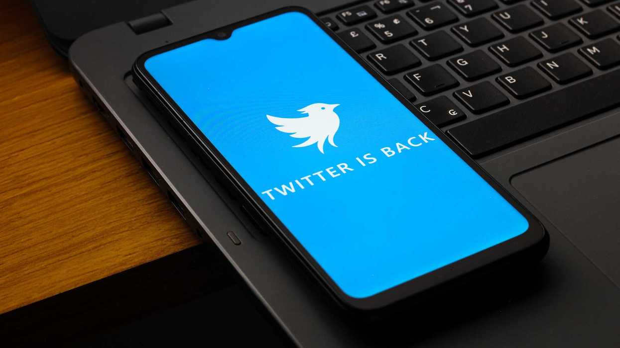 New twitter.now logo on a smartphone sitting on a laptop