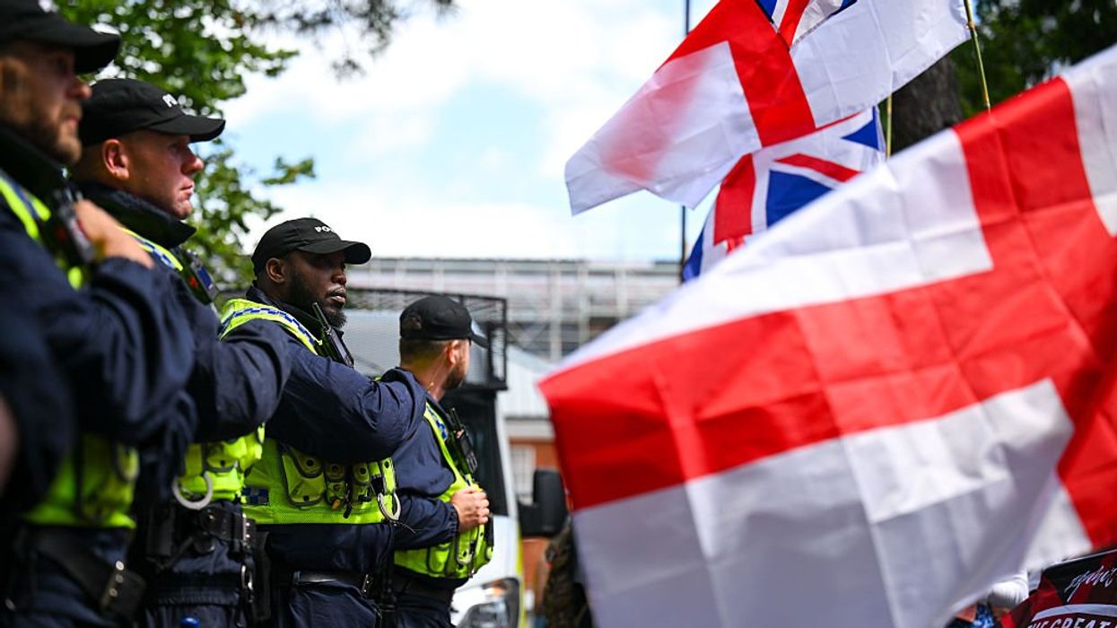 Police drag away a man for saying he likes bacon near a sprawling mosque construction site