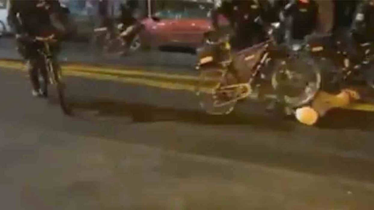 Protester lays face-down in Seattle street to block path of bicycle cops — and one officer just rolls right over his head