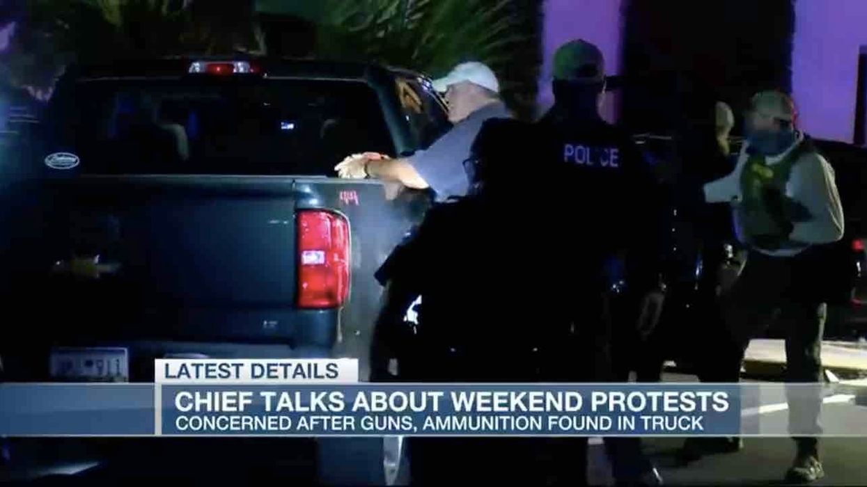 Protesters surrounding men in parked pickup truck allegedly pulled on vehicle's doors, got on hood before cops arrested men in truck on gun charges