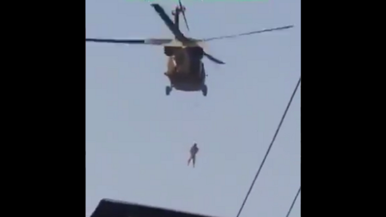 Shocking video shows man hanging from US Black Hawk as Taliban parades the skies over Afghanistan