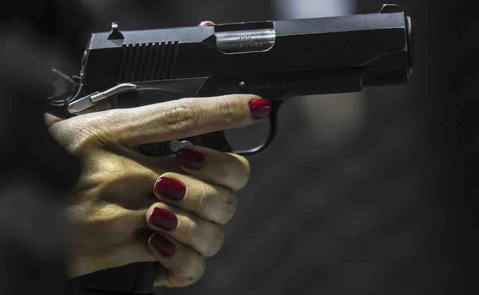 Stalker shows up at woman's workplace, begins punching her, cops say. But victim has a gun — and she uses it.